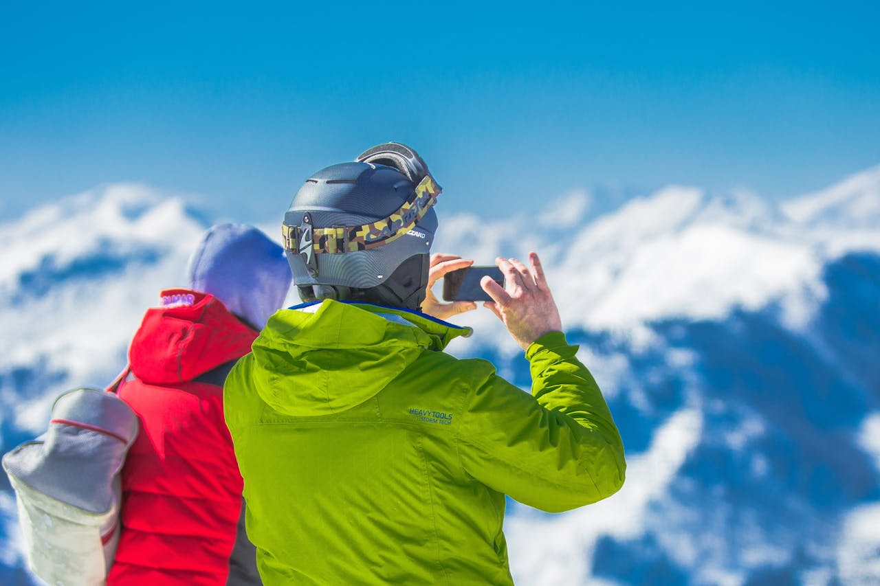 About Two skiers capturing the breathtaking mountain views on a snowy winter day.